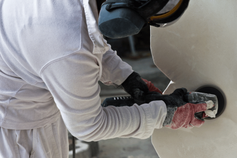 Travailleur en train de polir une surface en pierre naturelle avec des outils spécialisés.